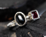 Oval black star diopside ring and garnet with sterling silver oxidized texture band