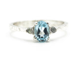 Blue topaz ring with tiny labradorite side set gems in prongs setting with sterling silver oxidized texture band