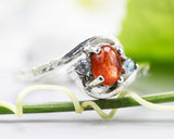 Oval sunstone ring with tiny labradorite side set gems in prongs setting with sterling silver texture band