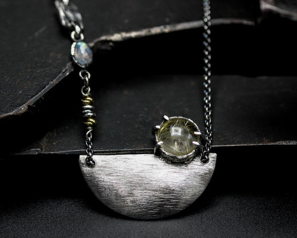 Rutilated quartz cabochon pendant necklace with silver plate in semi-oval shape on sterling silver chain