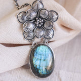 Oval Labradorite pendant necklace in silver bezel setting with silver in flower shape on silver chain
