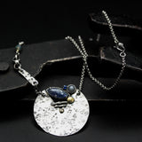 Marquise Iolite, moonstone and blue sapphire pendant necklace set in silver textured circle shape with sterling silver chain