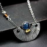 Round blue Kyanite gemstone pendant necklace with silver fan shape on sterling silver chain