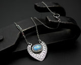 Oval cabochon Moonstone pendant necklace in silver bezel setting with silver in engraving technique