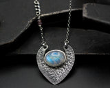Oval cabochon Moonstone pendant necklace in silver bezel setting with silver in engraving technique