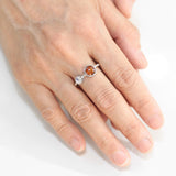 Round orange kyanite ring in silver bezel setting with Moonstone on the side on sterling silver hard texture band