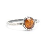 Round orange kyanite ring in silver bezel setting with sterling silver hammer texture band