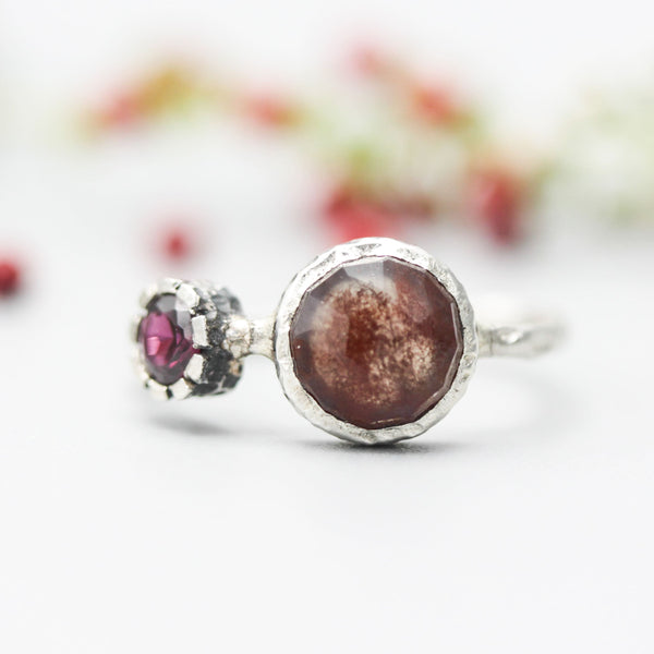 Round faceted Moss agate ring in silver bezel setting with garnet on oxidized sterling silver band