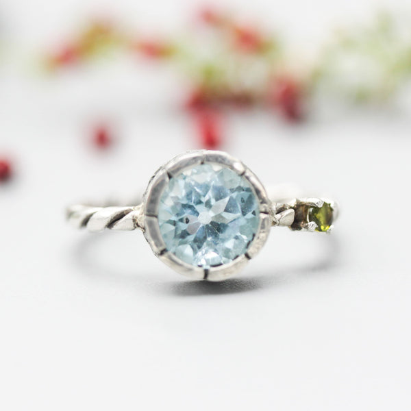 Swiss blue topaz ring in silver bezel setting and tiny green tourmaline on the side with sterling silver twist design band