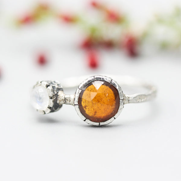 Round orange kyanite ring in silver bezel setting with Moonstone on the side on sterling silver hard texture band