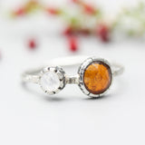 Round orange kyanite ring in silver bezel setting with Moonstone on the side on sterling silver hard texture band